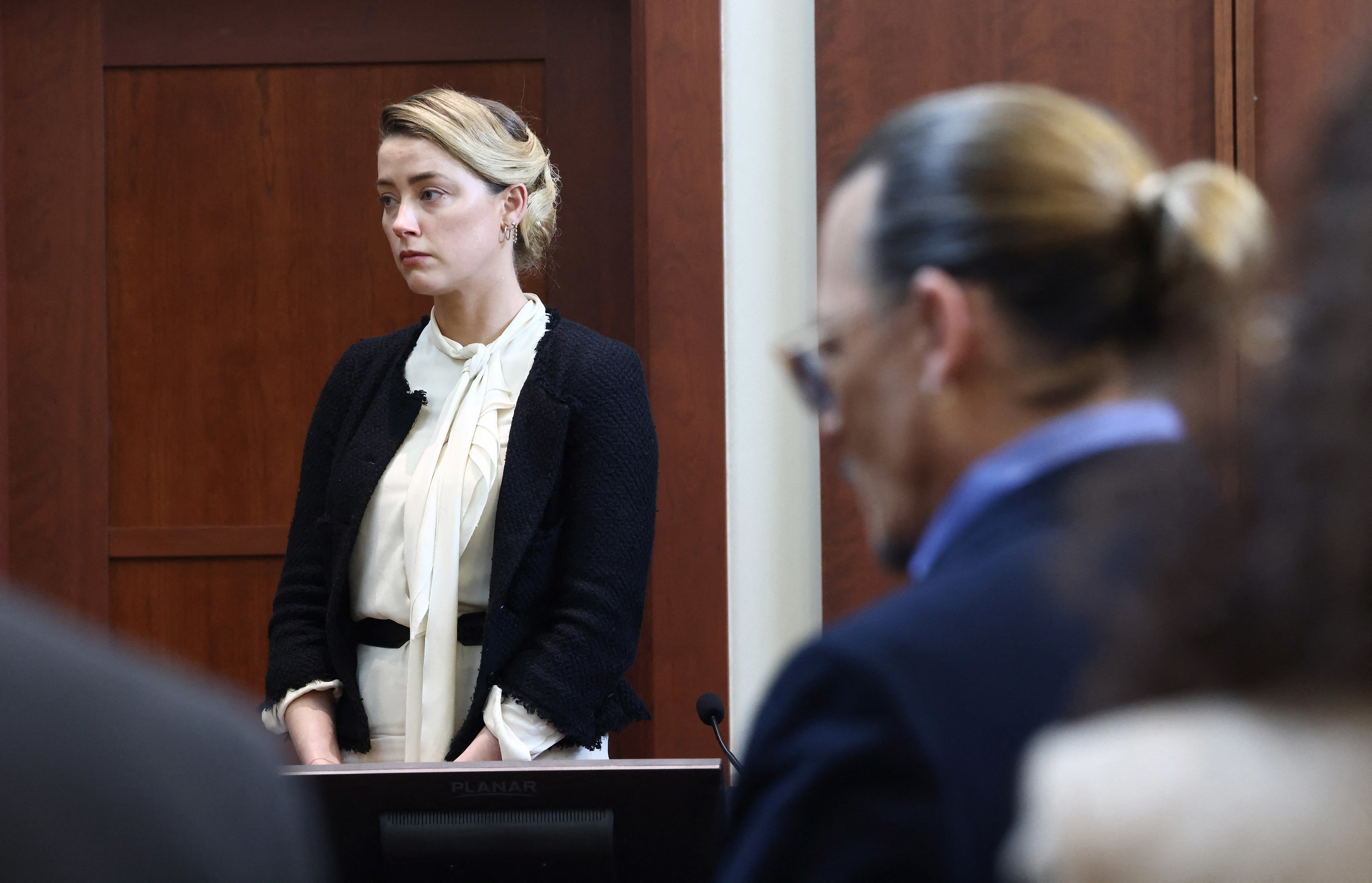 amber in the courtroom looking somber with Johnny Depp in the foreground