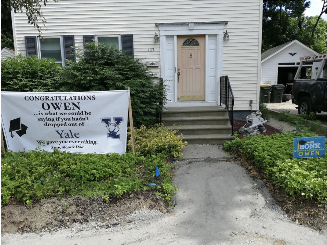 Sign on the front yard of a house: &quot;&#x27;Congratulations OWEN&#x27; is what we could be saying if you hadn&#x27;t dropped out of Yale; we gave you everything, xoxo Mom &amp;amp; Dad&quot; with the Yale logo and image of a mortarboard
