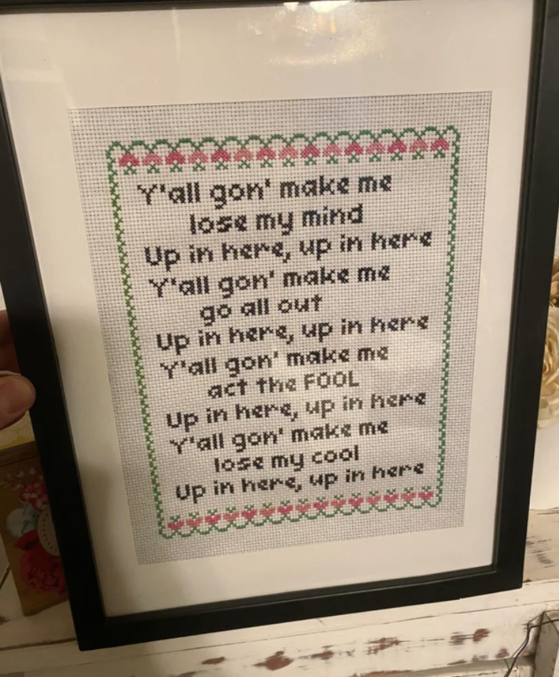 A framed sign with a &quot;homey,&quot; old-fashioned style, with lyrics from DMX&#x27;s &quot;Party Up,&quot; including &quot;Y&#x27;all gon&#x27; make me lose my mind / Up in here, up in here / Y&#x27;all gon&#x27; make me go all out / Up in here, up in here&quot;