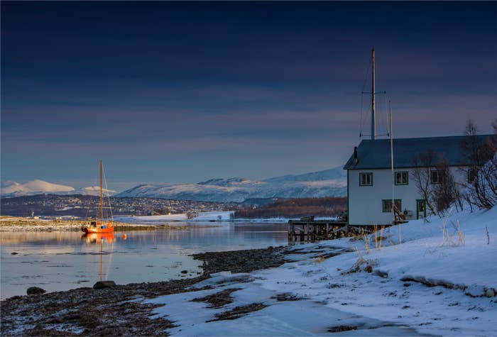 Scene of a small house and a boat in a snowy arctic landscape in Tromsø, Norway