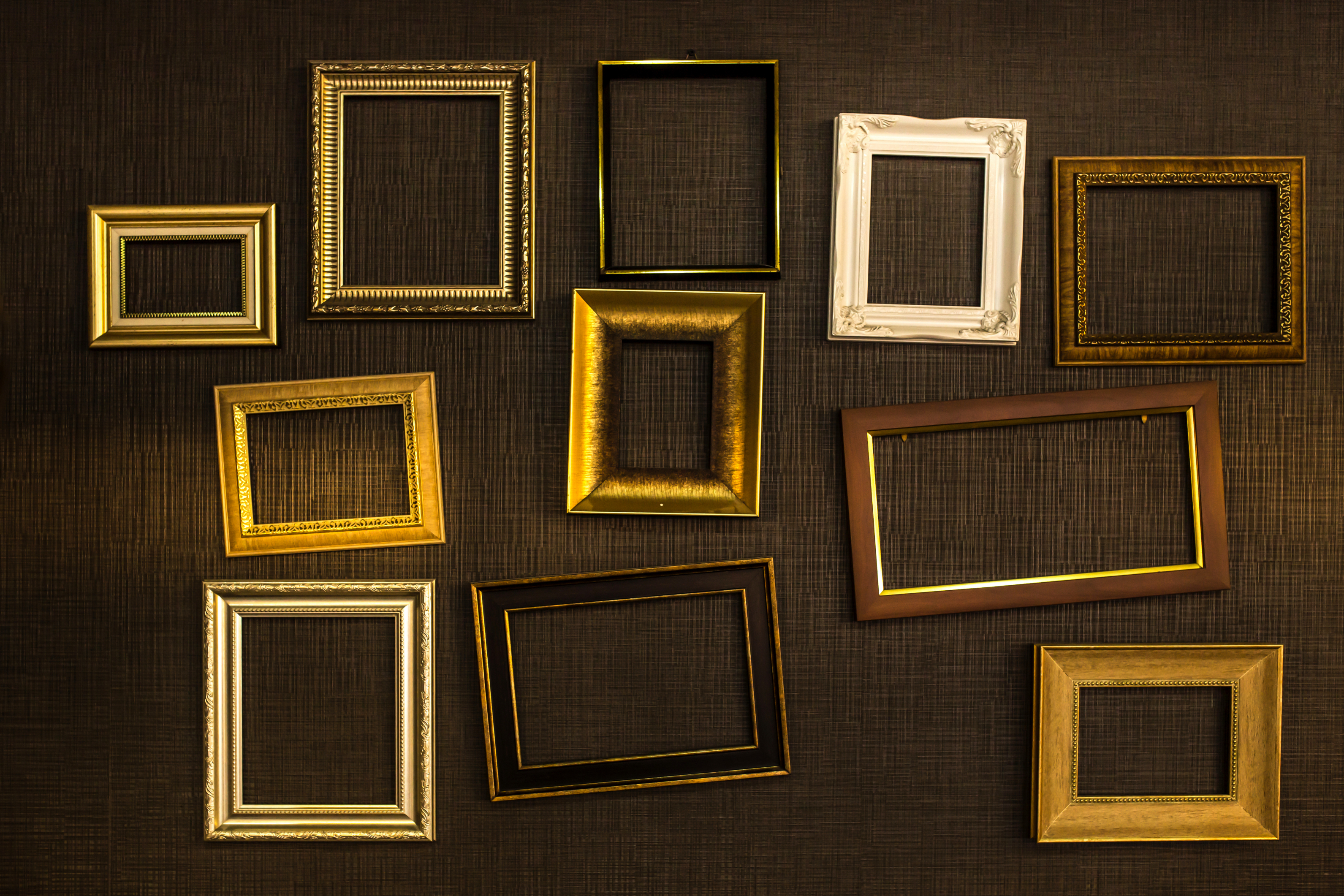 Empty picture frames hang on a wall