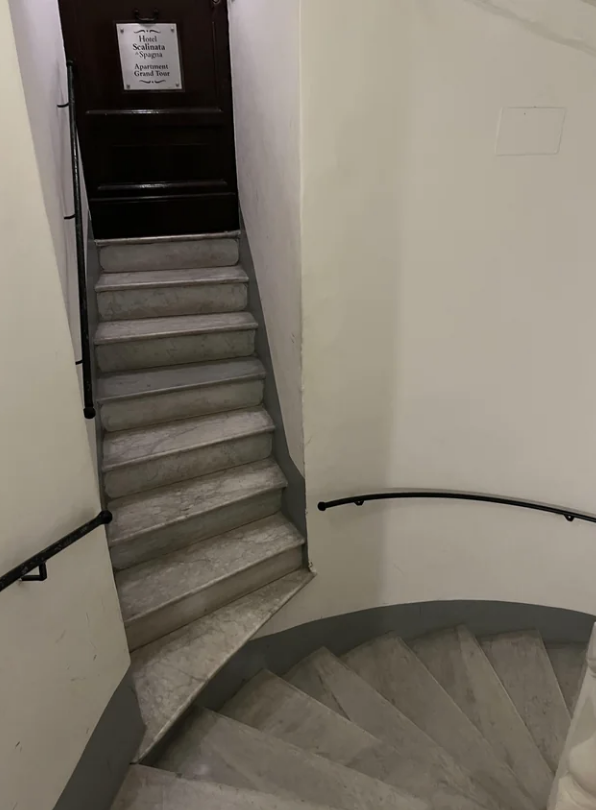 very narrow staircase leads to another staircase without a flat surface