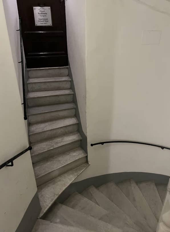 very narrow staircase leads to another staircase without a flat surface