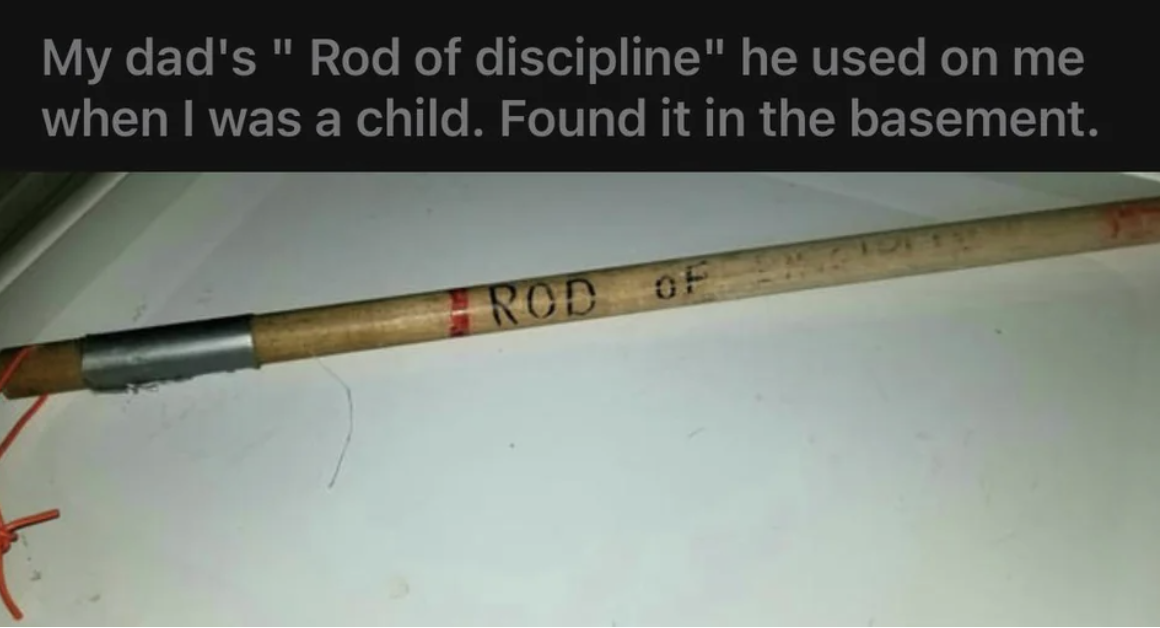 Close-up of a long, thick wooden stick with &quot;Rod of discipline&quot; written on it