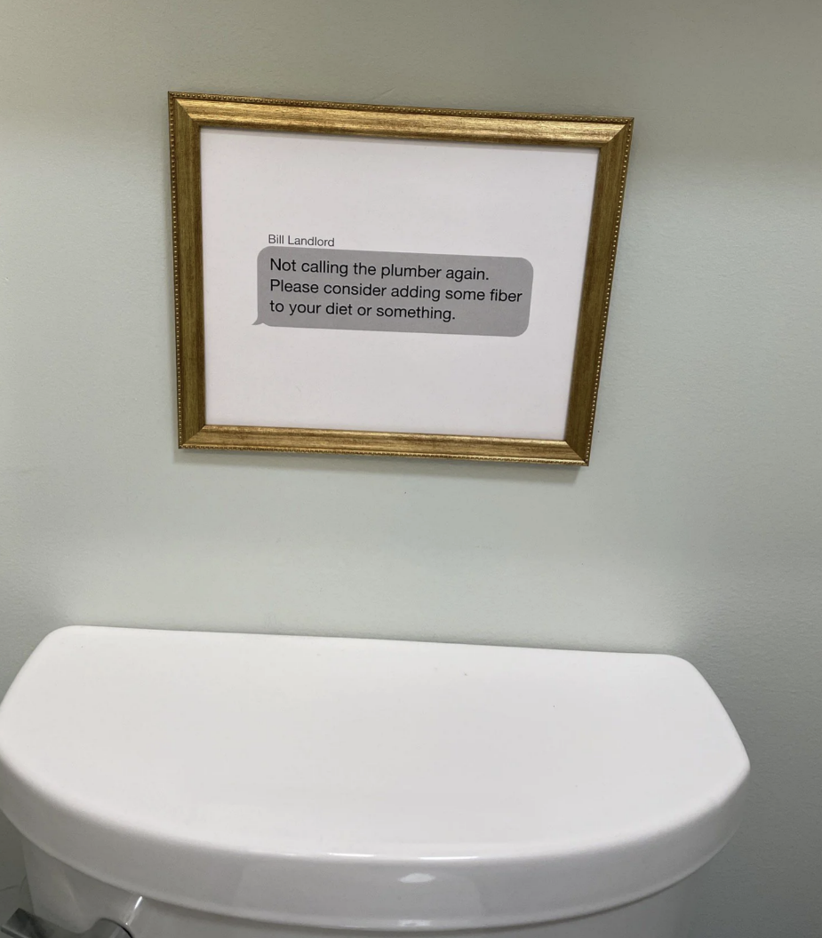 framed text message from the landlord hung about the toilet that reads, not calling the plumber again, please consider adding some fiber to your diet or something