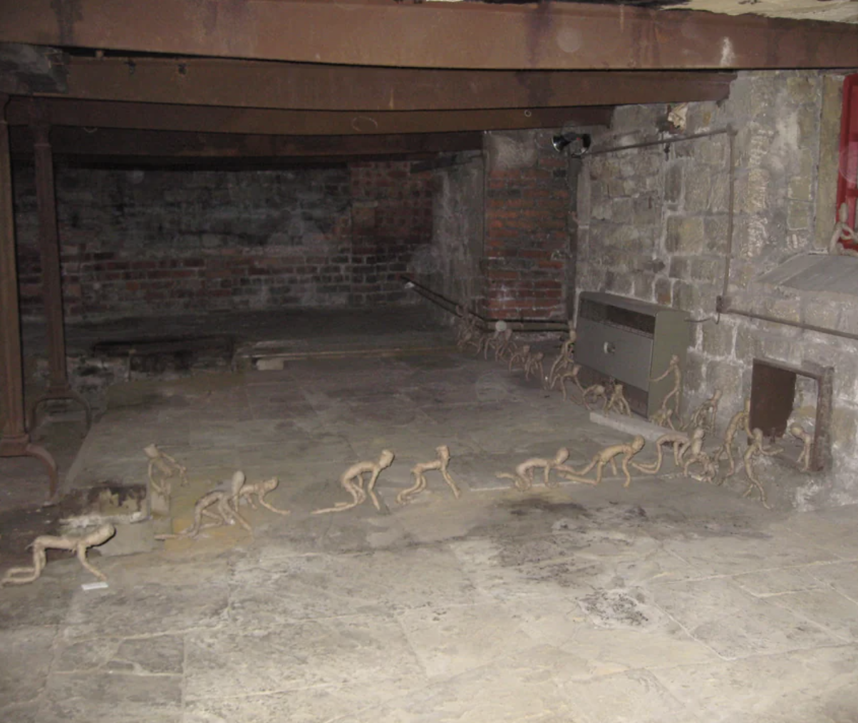Exposed brick walls in a basement with small stick-figures in a row on the floor in various crouched positions