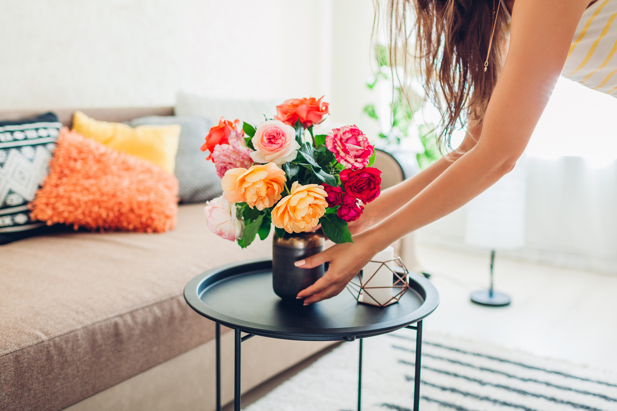A woman arranging flowers on her coffee table