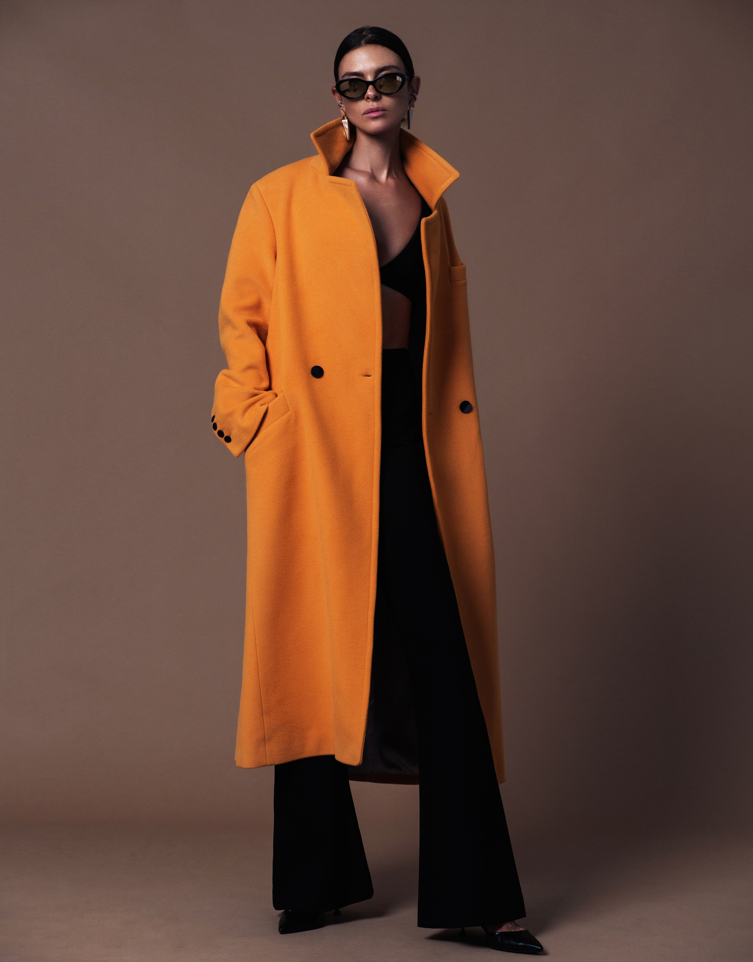 A woman modeling an orange coat