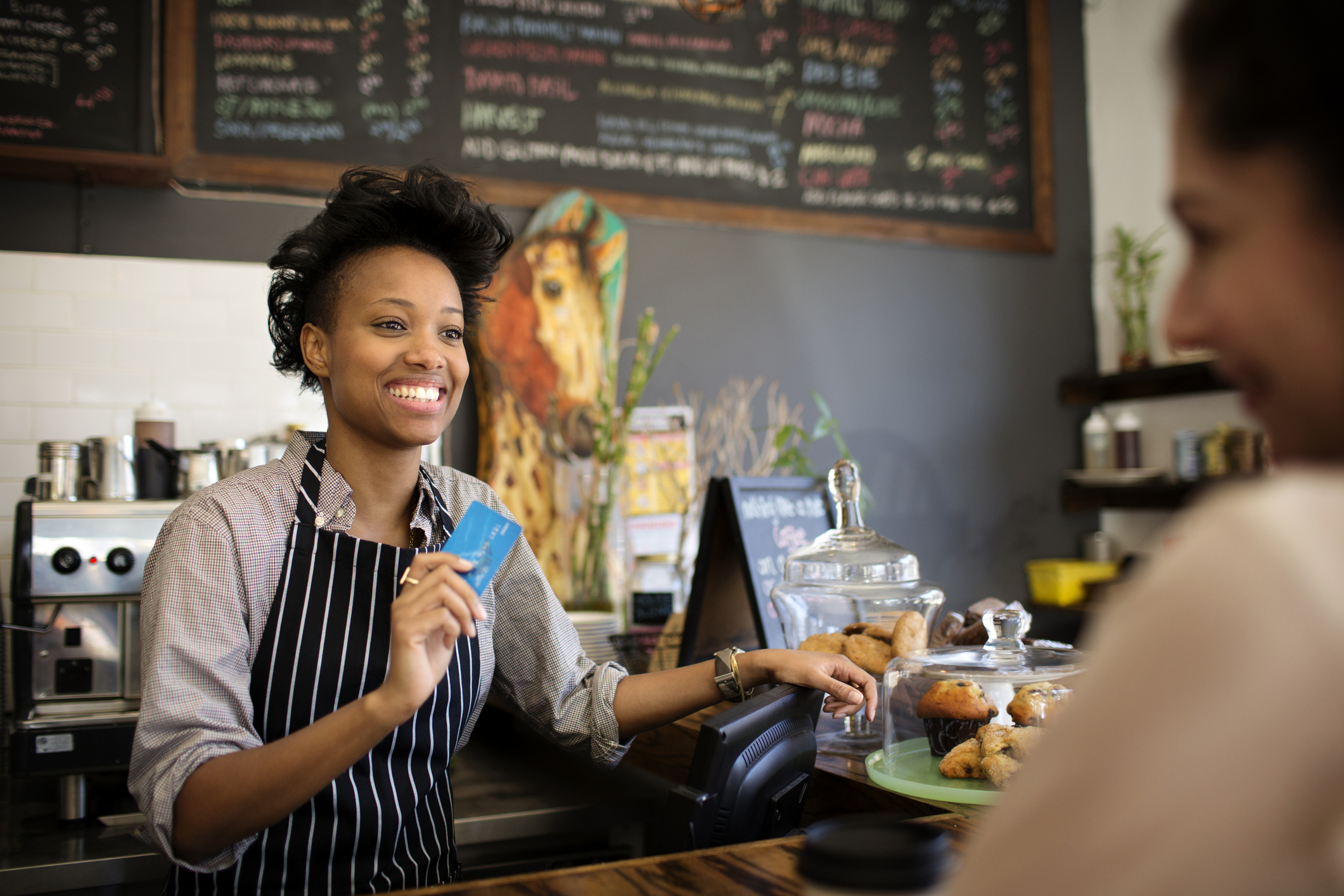A barista taking a customer's credit card