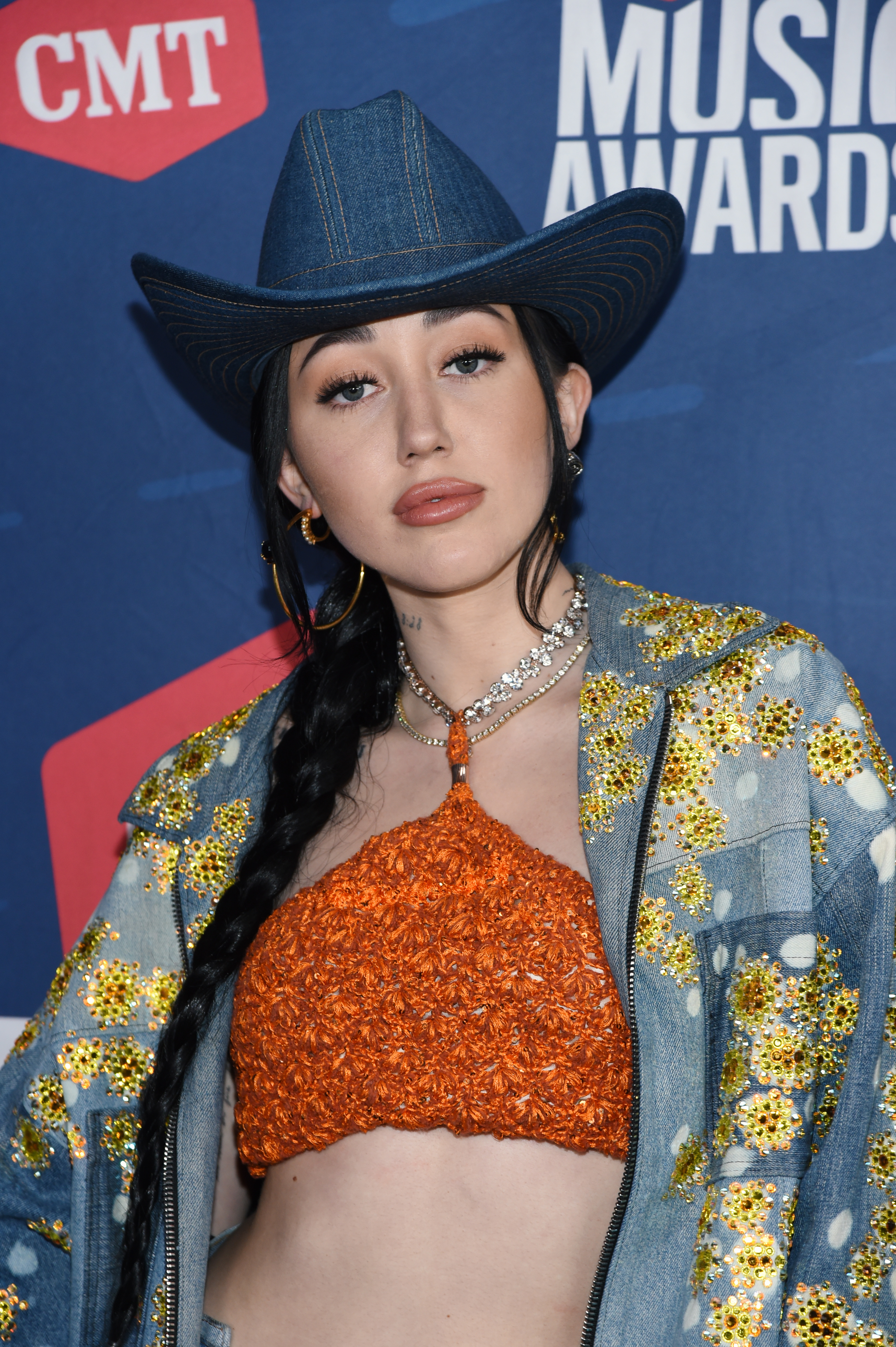 Close-up of Noah in a Western-style denim hat and glittery crop top and glittery denim jacket