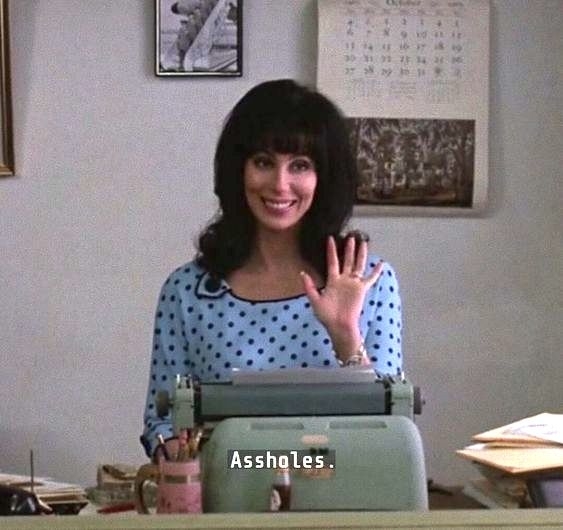 Cher in "Mermaids" saying assholes as she waves from her desk