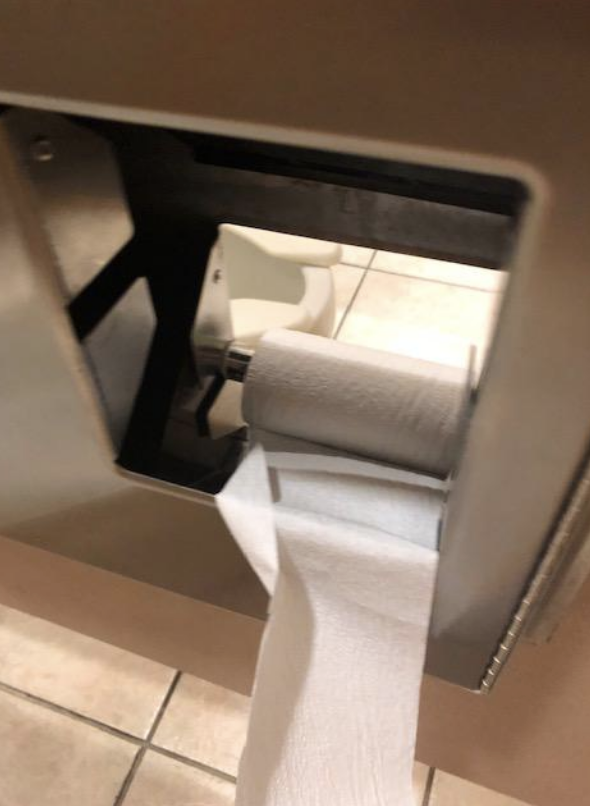 a hole where the toilet paper is so you can see into the other stall