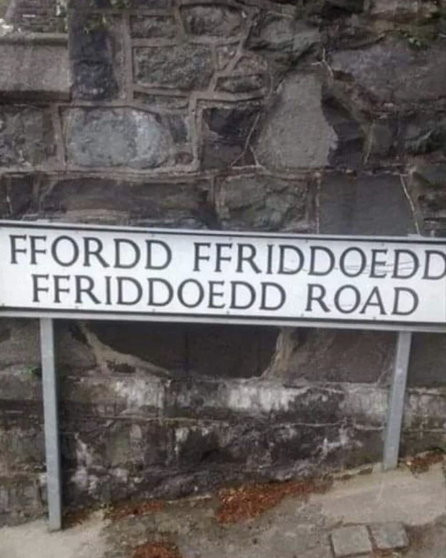 A street sign says &quot;Ffordd Ffriddoedd Ffriddoedd Road&quot;