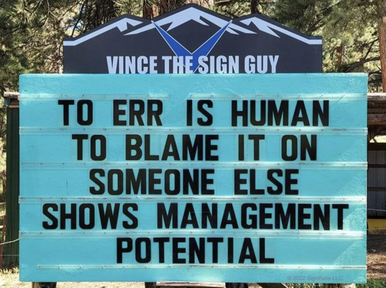 The sign says &quot;to err is human, to blame it on someone else shows management potential&quot;