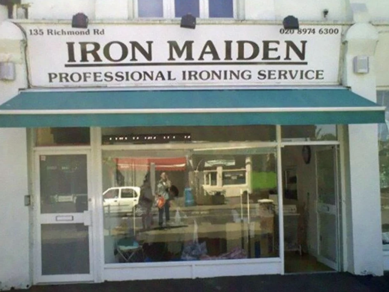 The sign above a small shop says &quot;Iron Maiden: professional ironing service&quot;