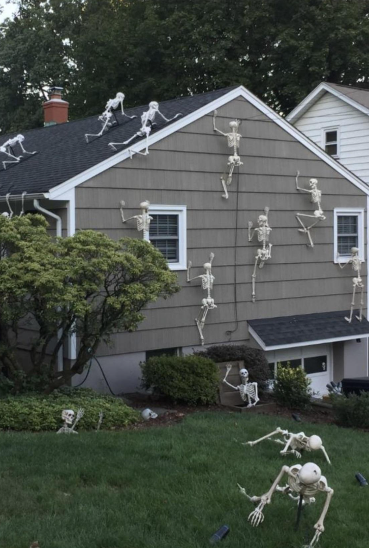A property covered in skeletons that all are displayed as if they&#x27;re running toward the house and trying to climb up it