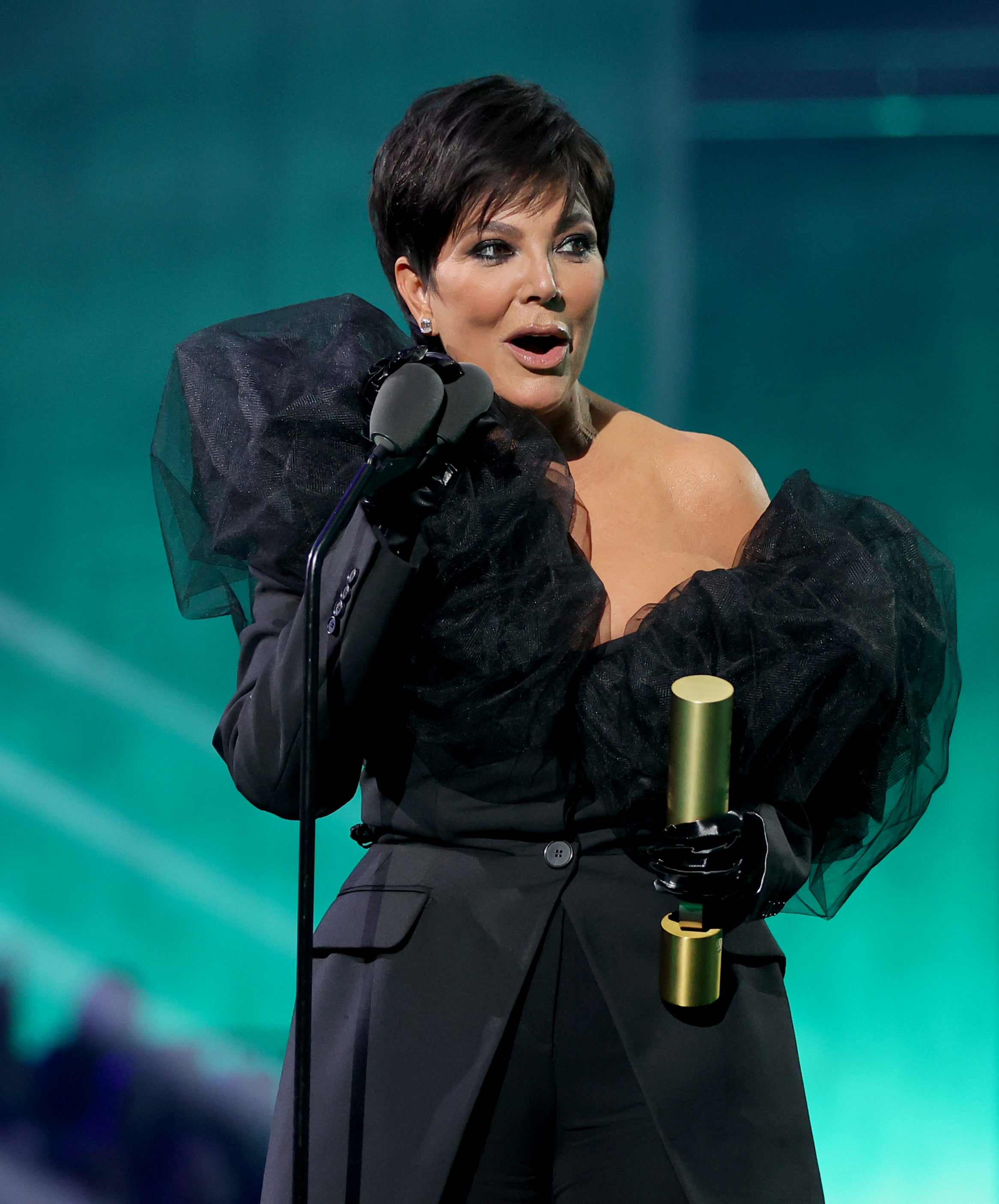 Close-up of Kris onstage holding an award