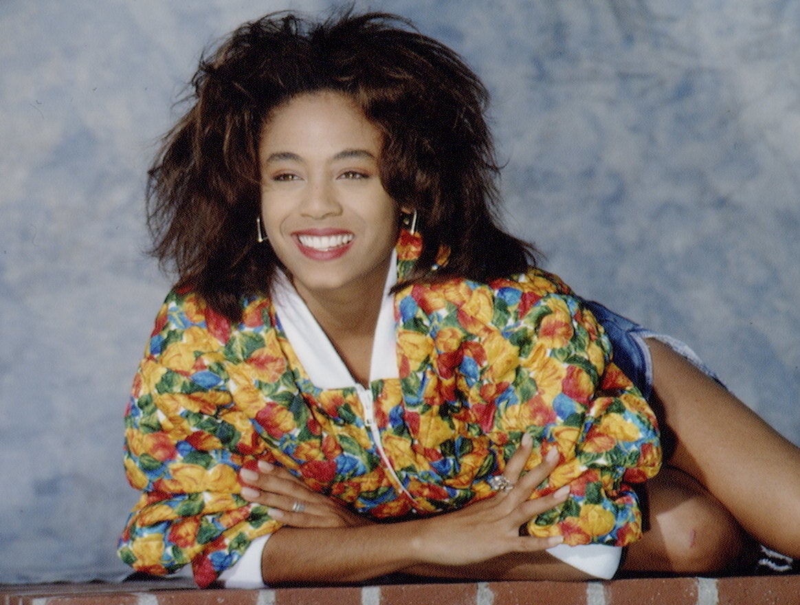 Close-up of a younger Jada smiling and posing