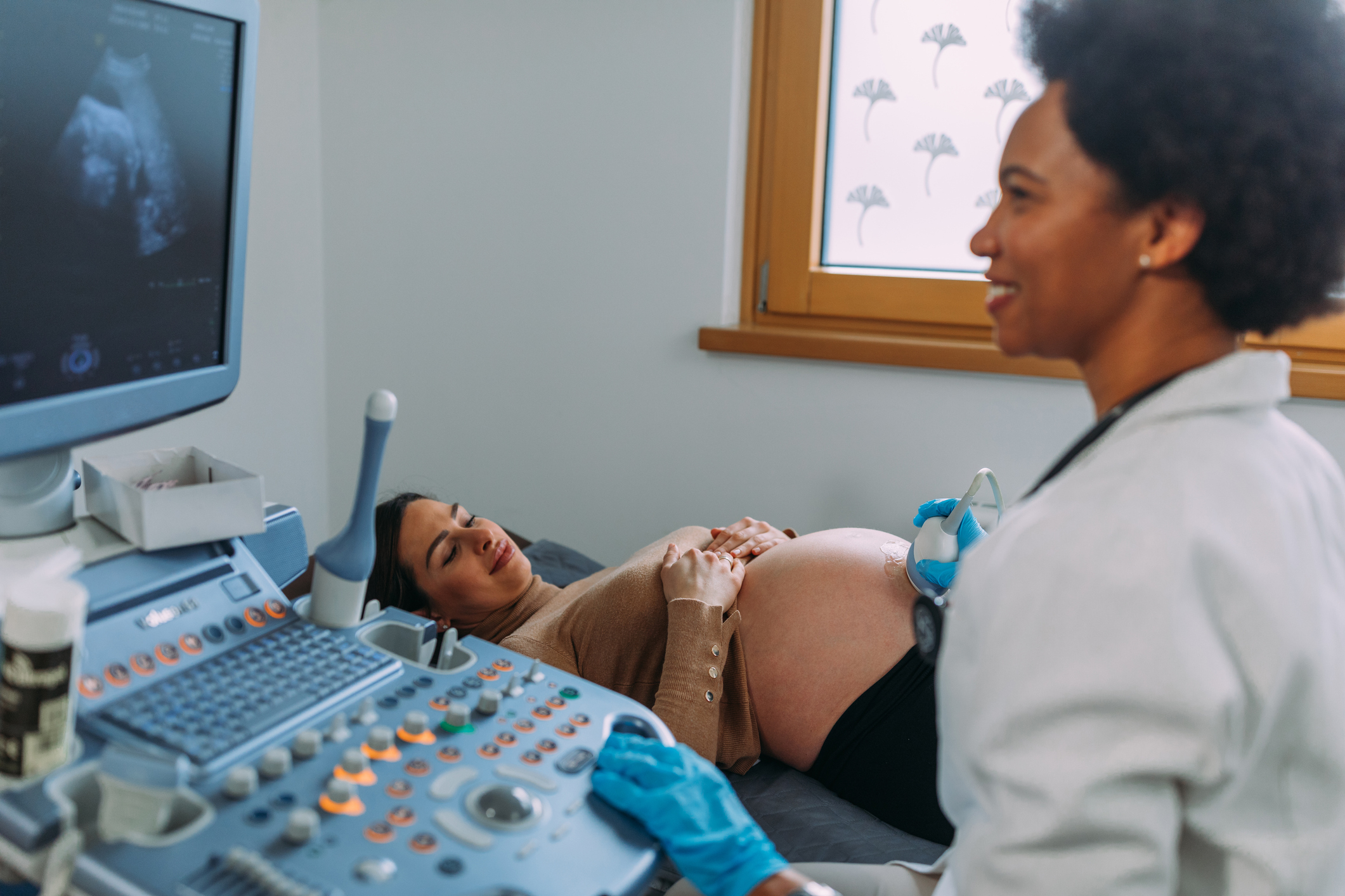 An ultrasound technician gives a pregnant person an ultrasound