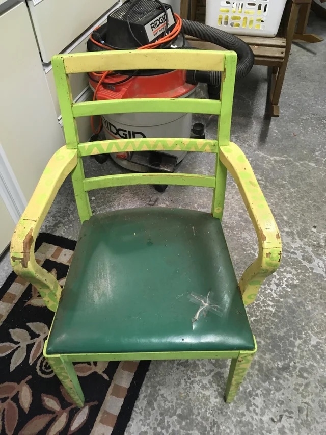 A before image of a chair painted green and yellow with a torn green leather cushion