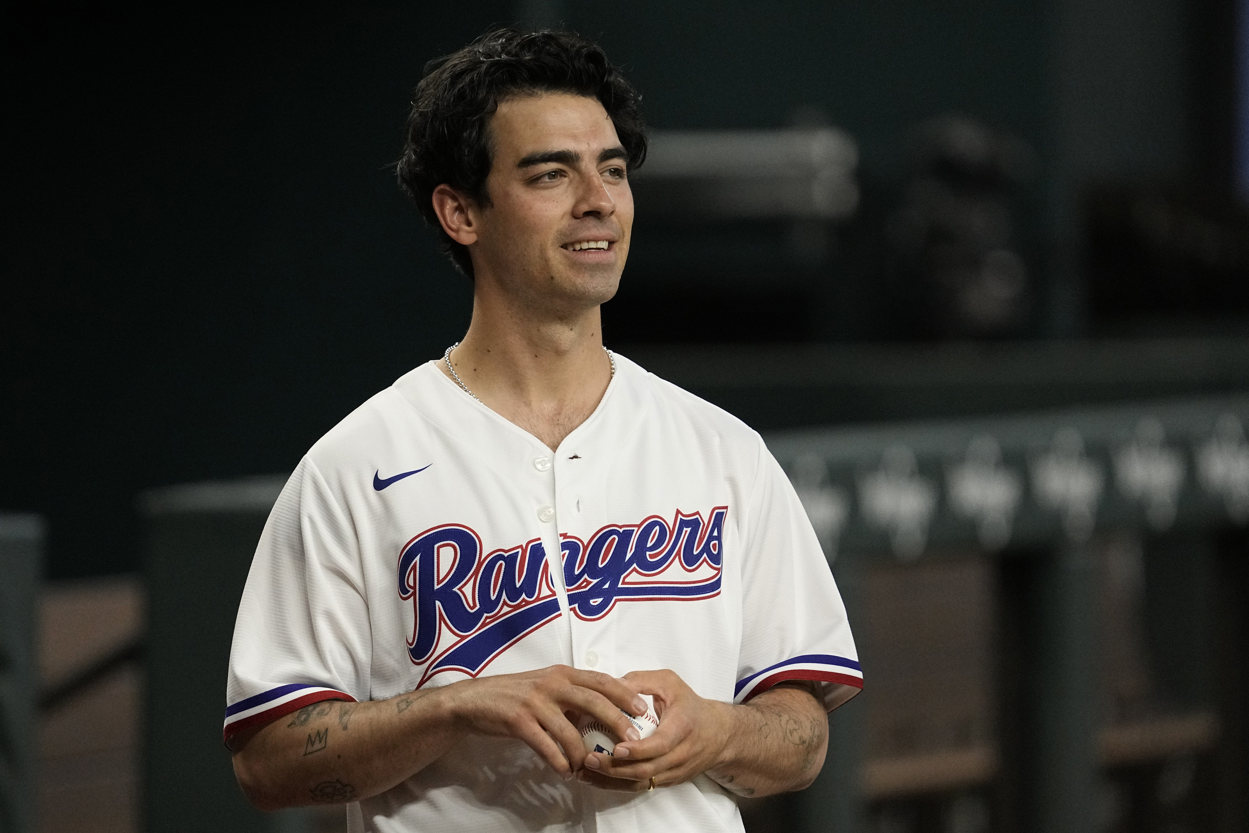 Close-up of Joe in a baseball jersey and holding a baseball