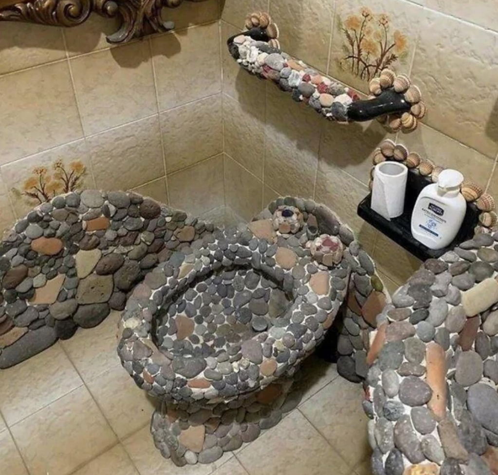 stone covered toilet and sink in a bathroom
