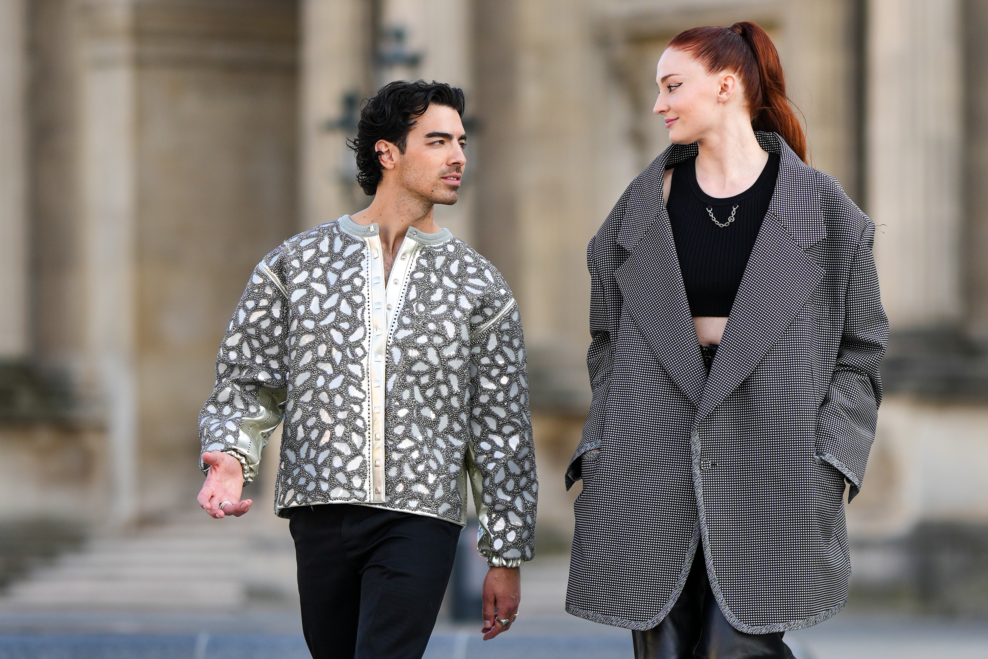 Close-up of Joe and Sophie walking together and wearing jackets
