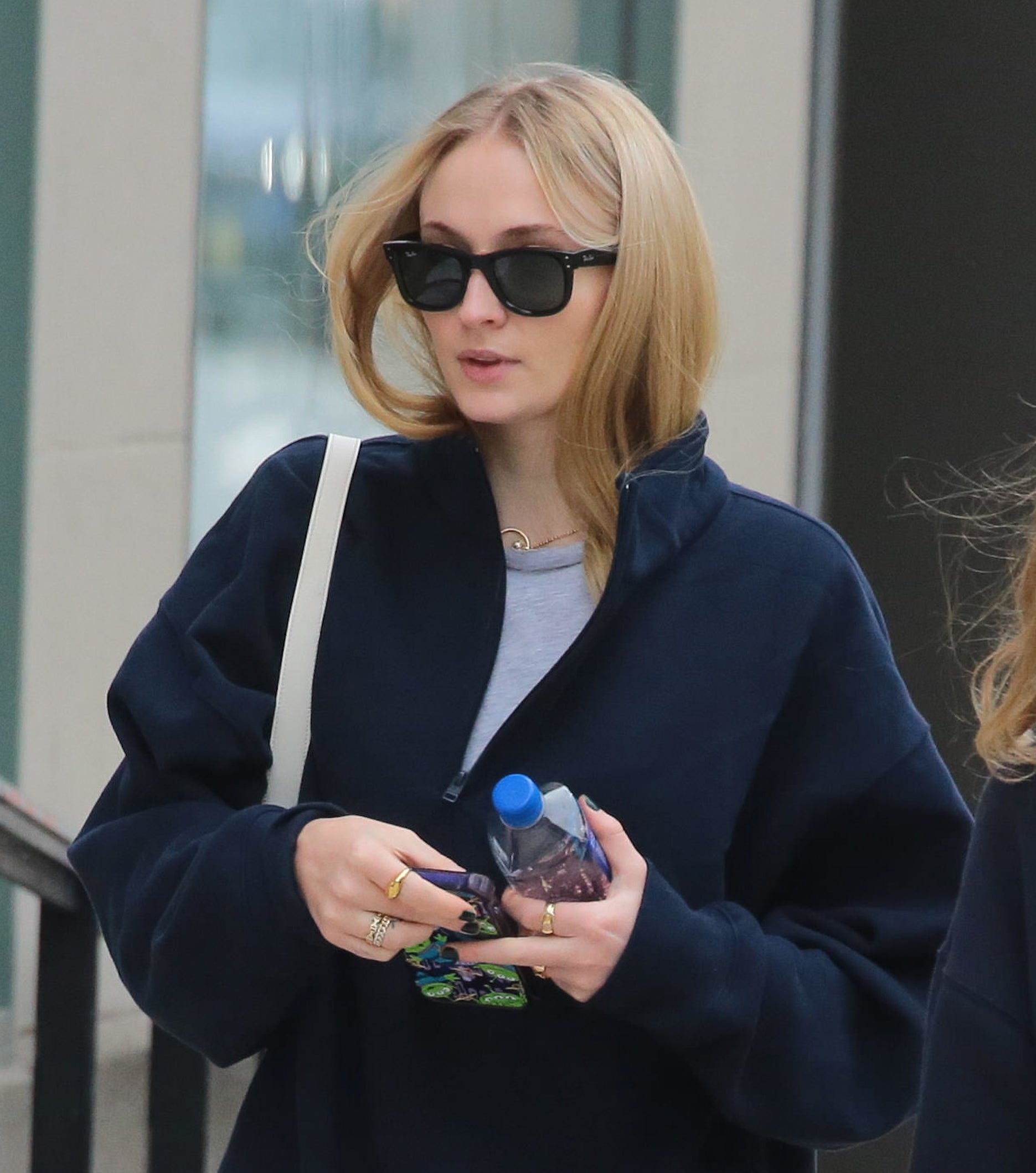 Sophie walking outside holding a bottle of water