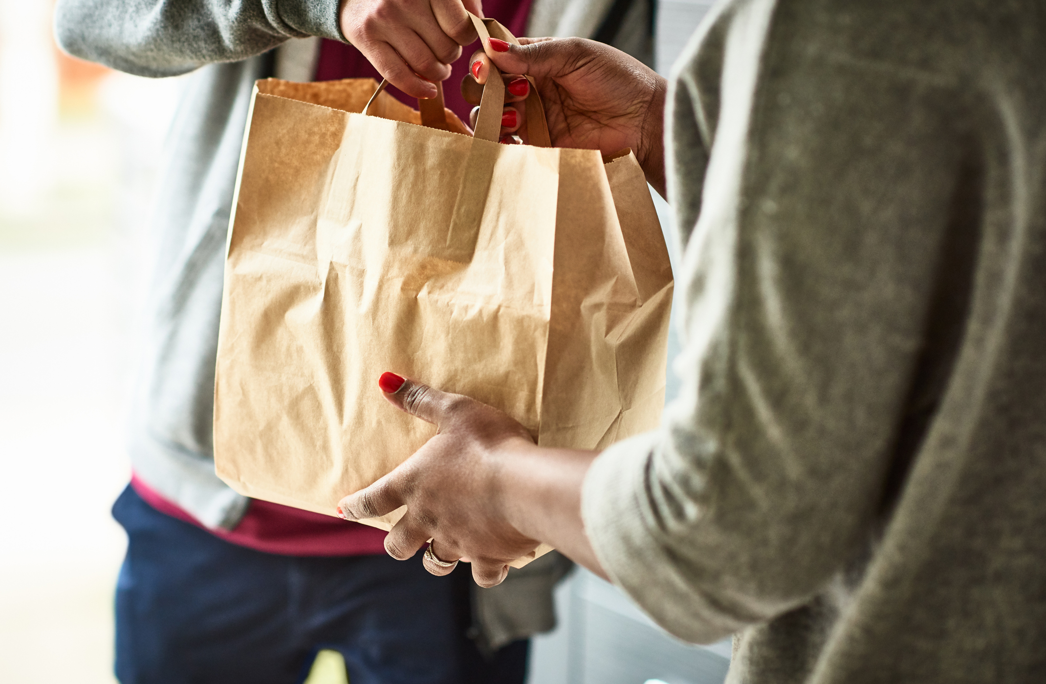 person handing over a bag of food