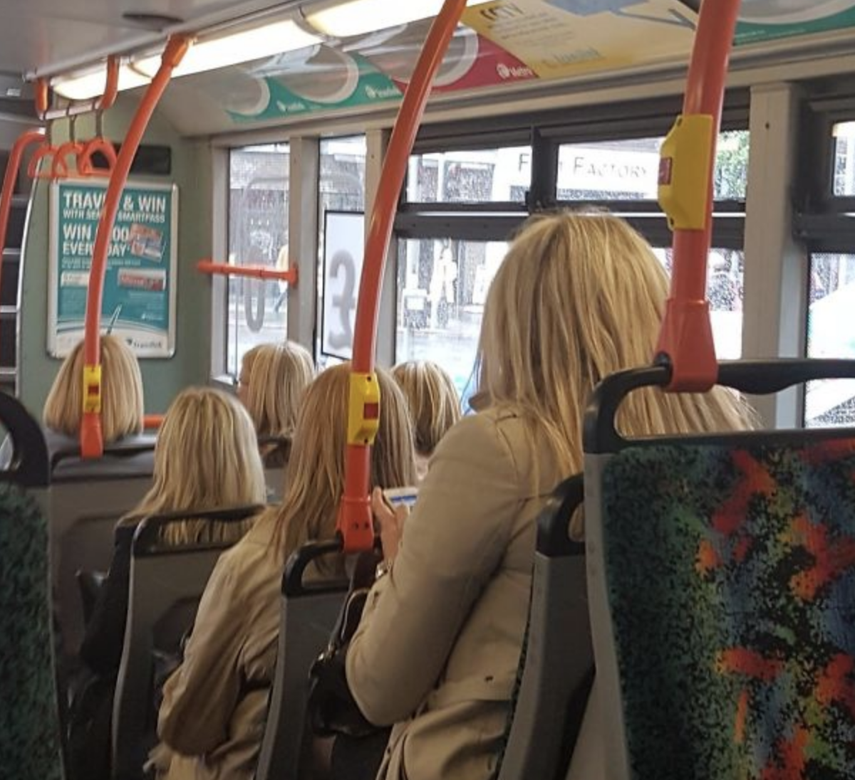 People dressed the same and all with blonde hair on a bus