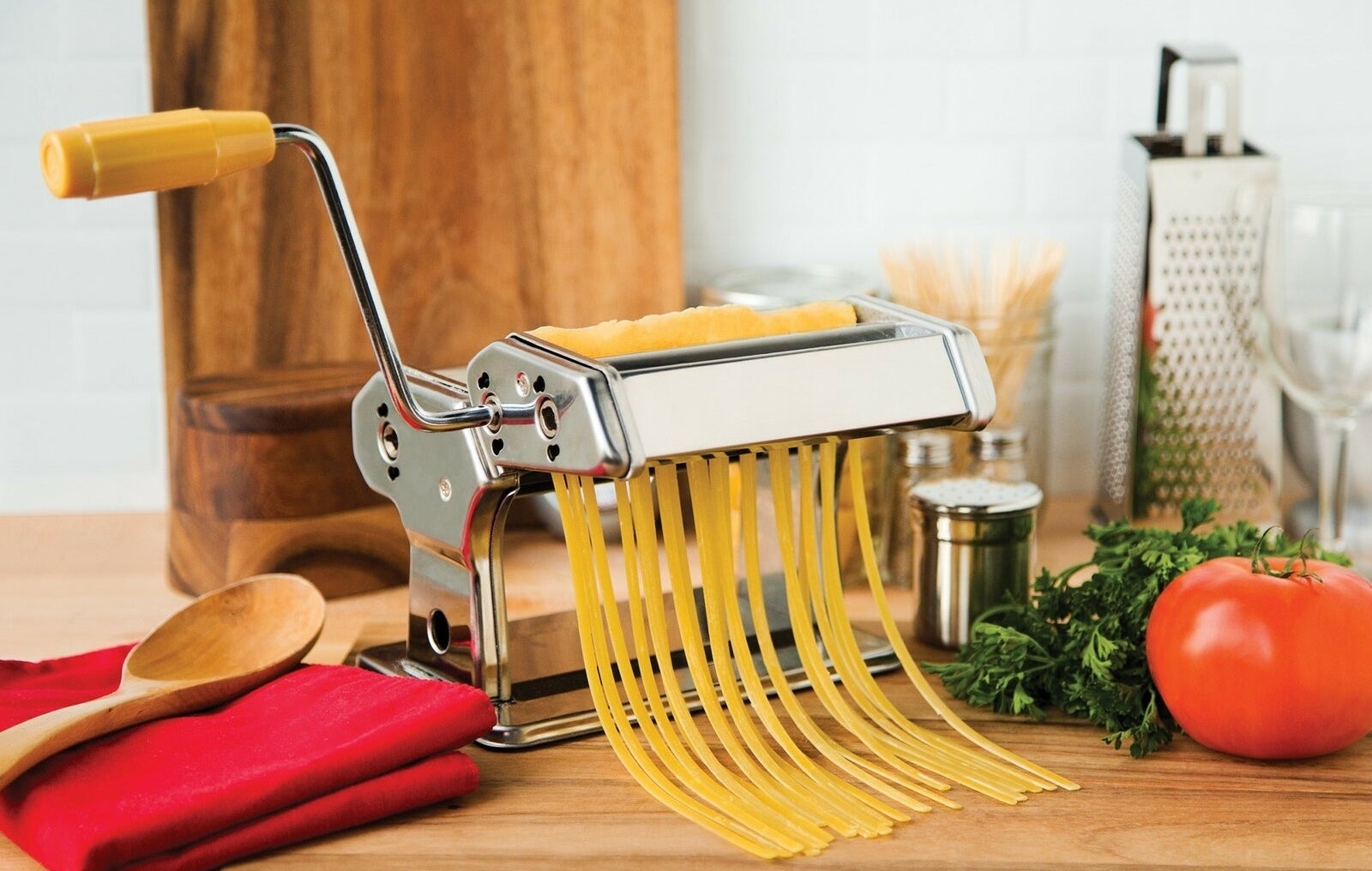 Stainless steel pasta maker on a kitchen counter.