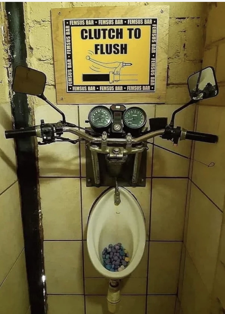 handles to a motorcylce put above a urinal