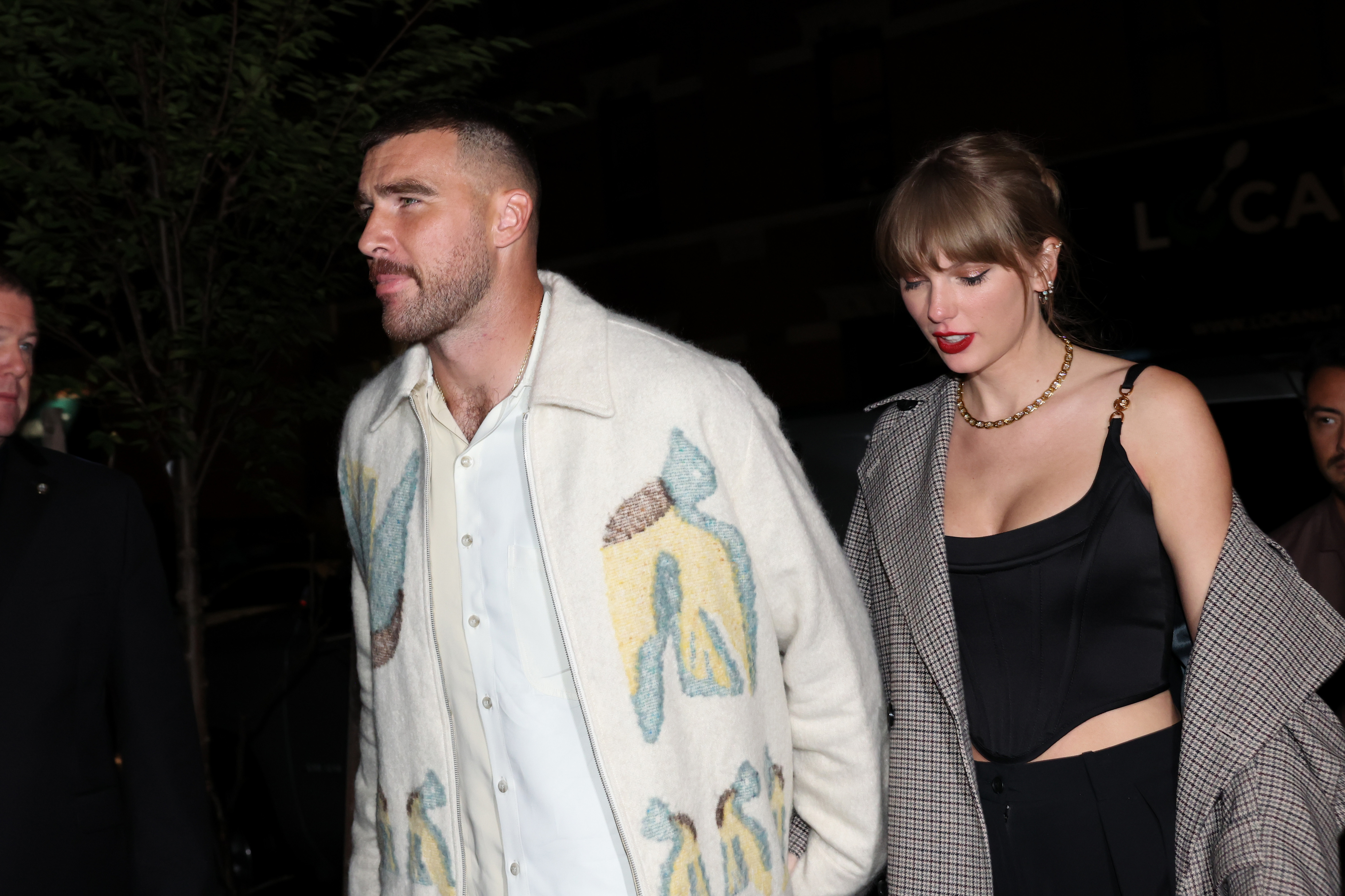 Close-up of Taylor and Travis holding hands and walking