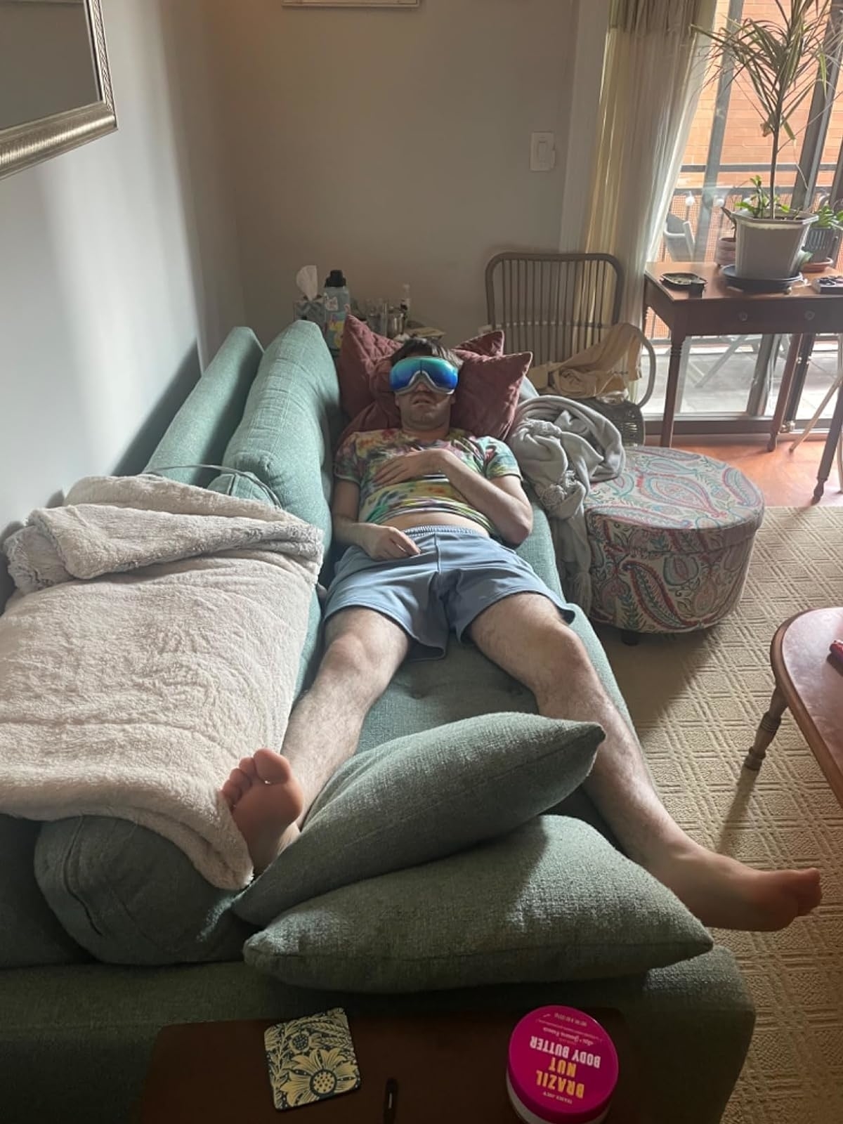 Reviewer laying on couch with eye massager on face