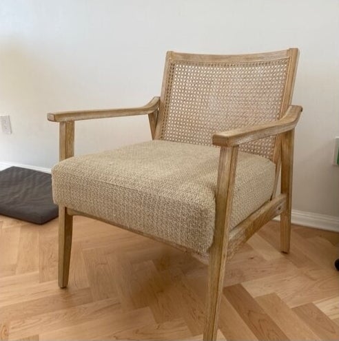 the wooden chair with a cushion and cane back