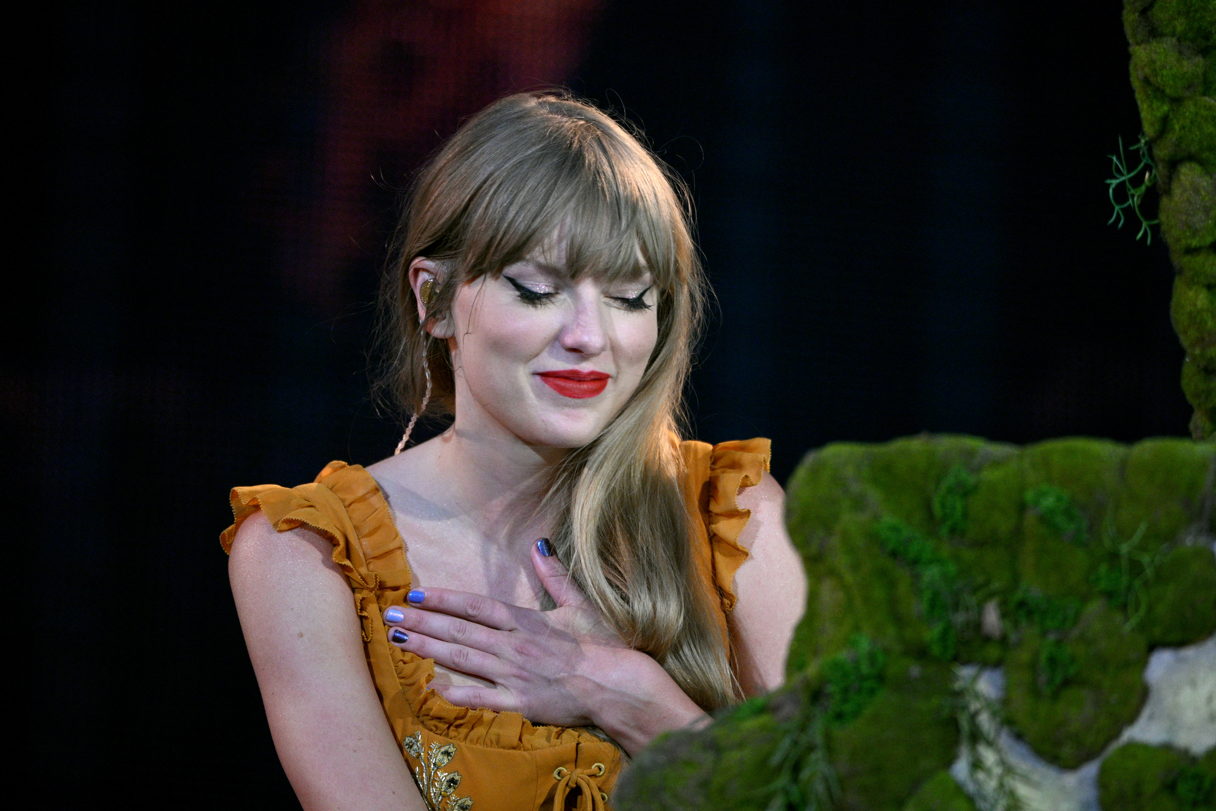 Taylor smiling with her eyes closed and her hand on her chest