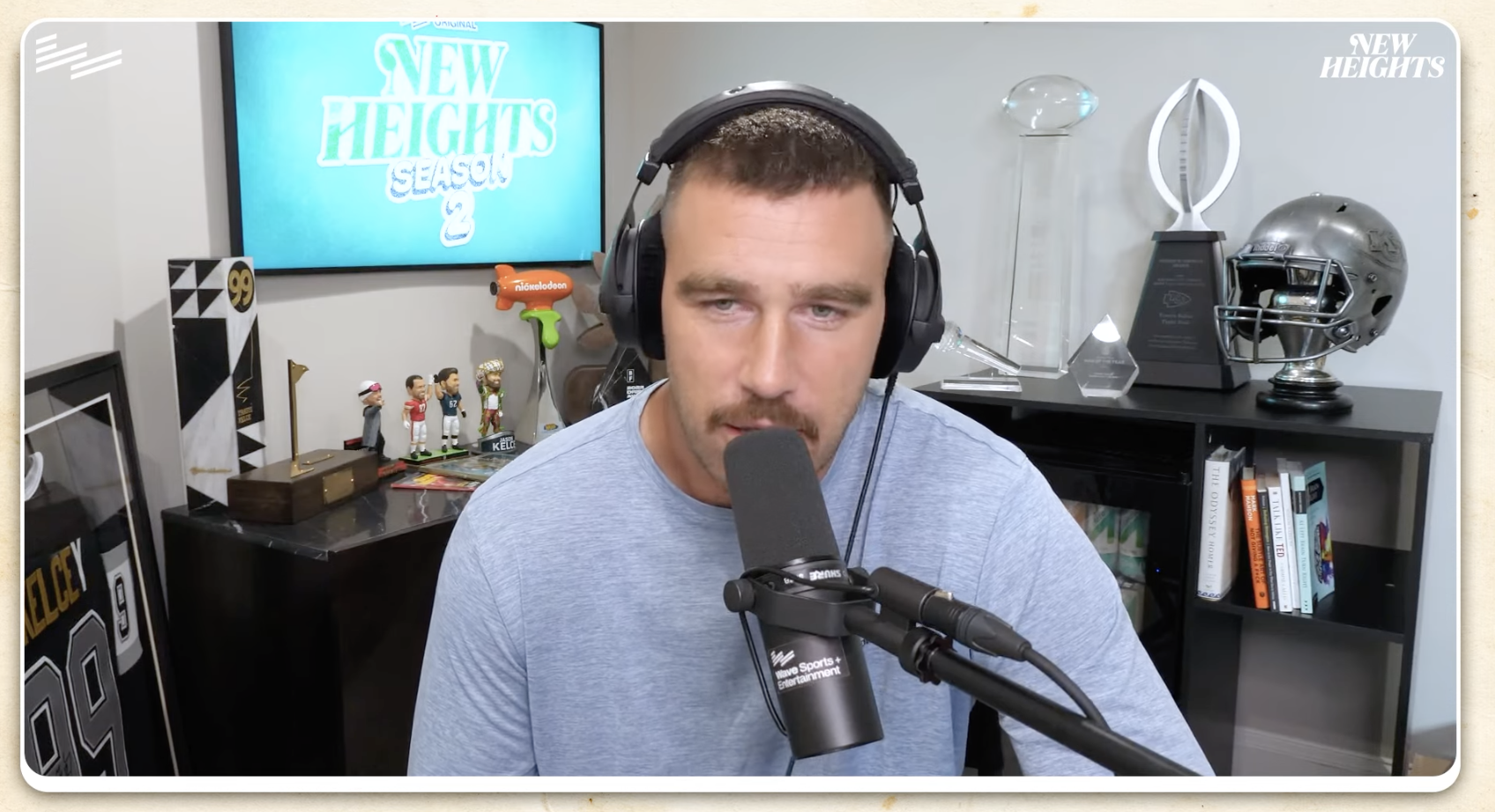 Travis sitting at a microphone and wearing headphones on the podcast