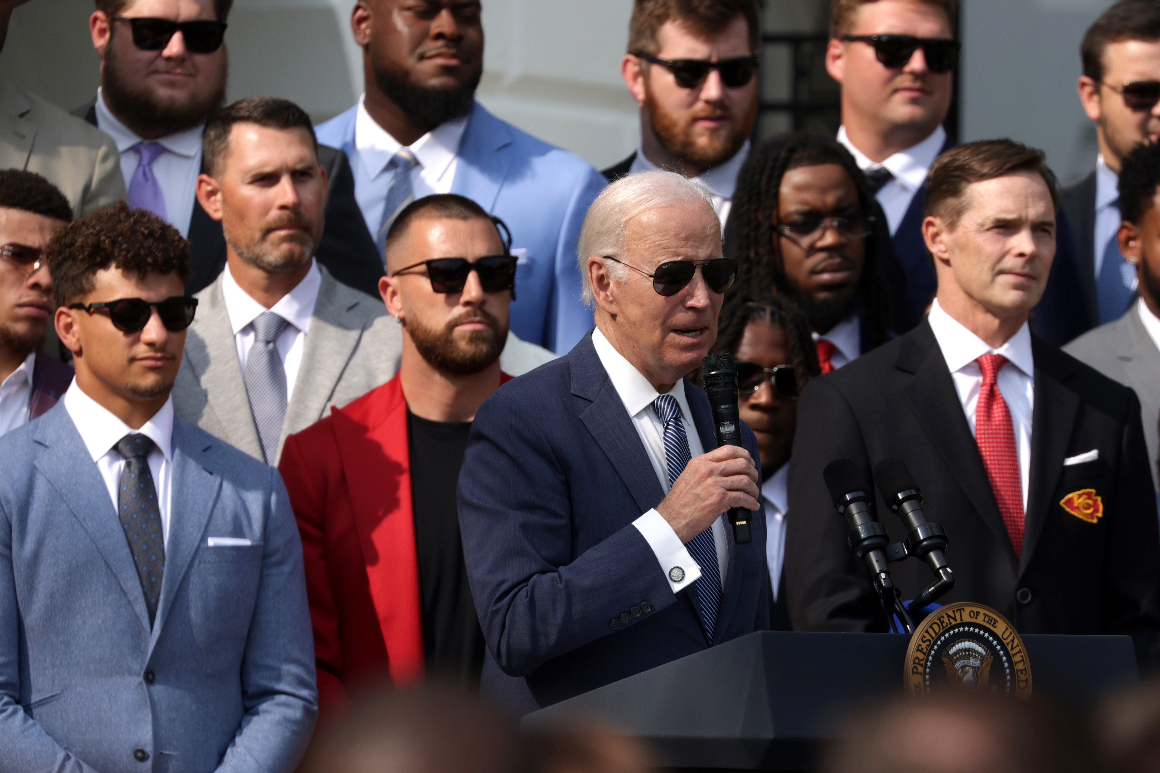 Biden at a podium with the team behind him