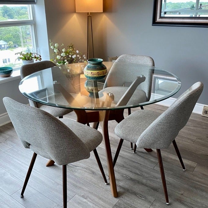 The set of grey upholstered dining chairs around a reviewer's table