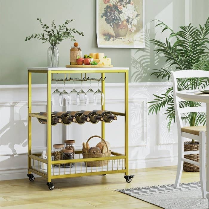 gold-tone bar cart with wine bottle and glass storage