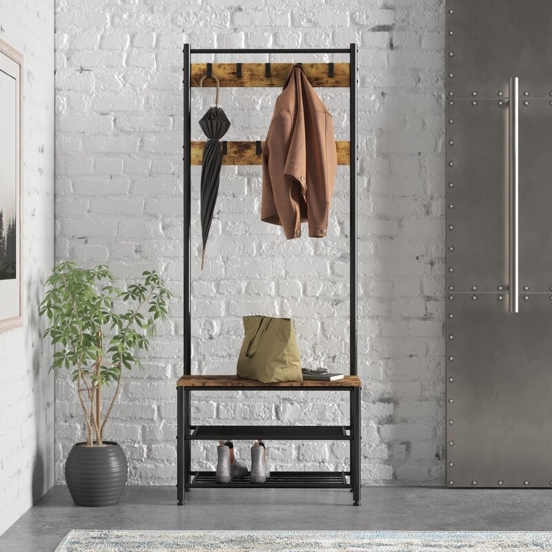 dark brown and black hall tree with coat rack hooks and shoe storage on bottom