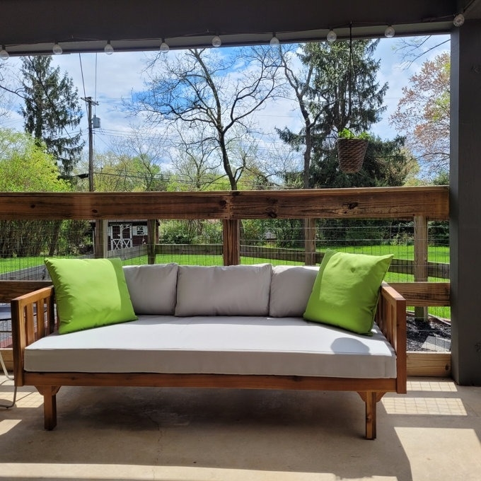 The daybed on a reviewer&#x27;s porch with green pillows