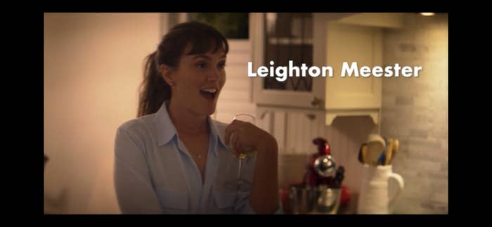 Leighton Meester laughs while holding a glass of wine