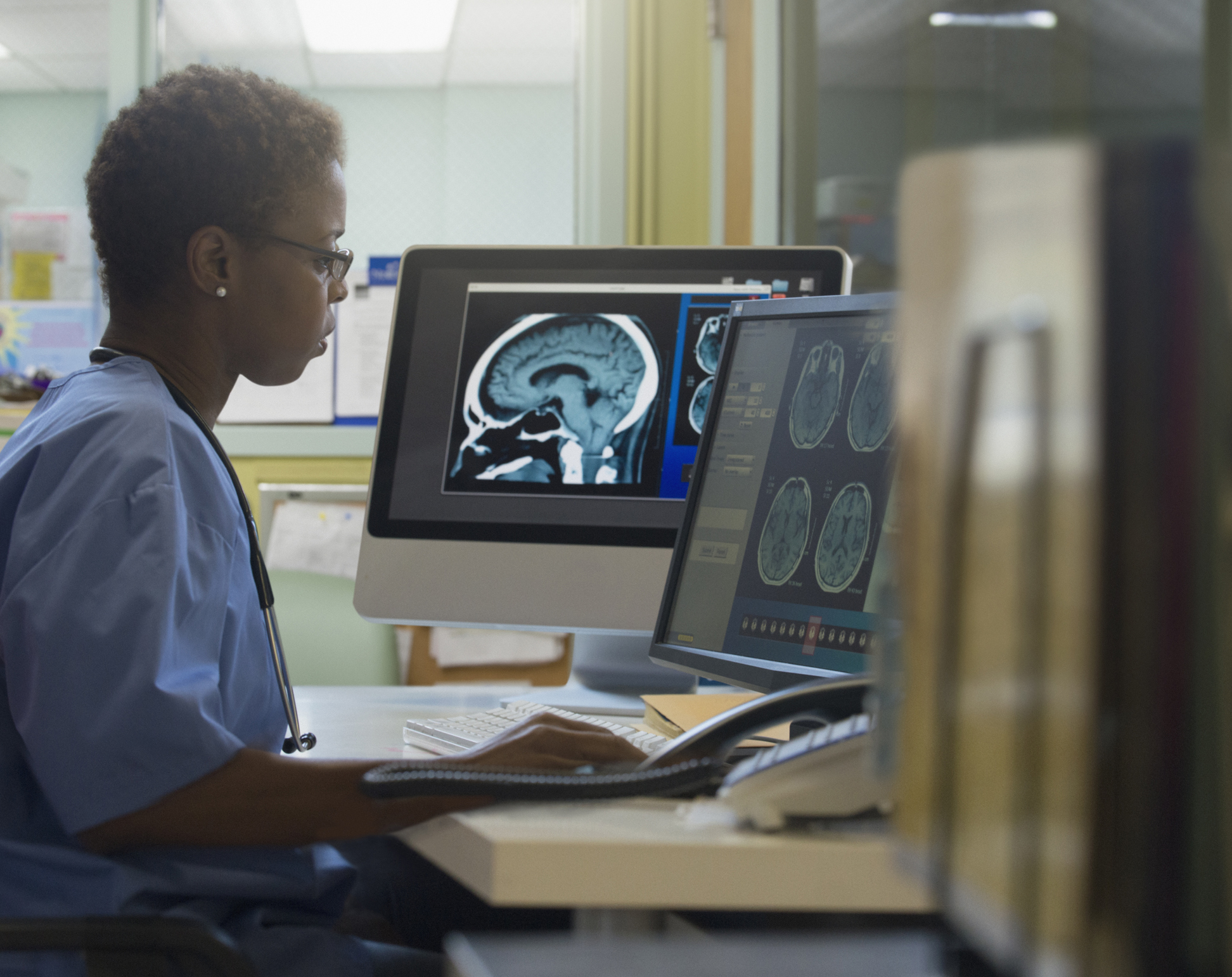 A radiology worker behind a computer