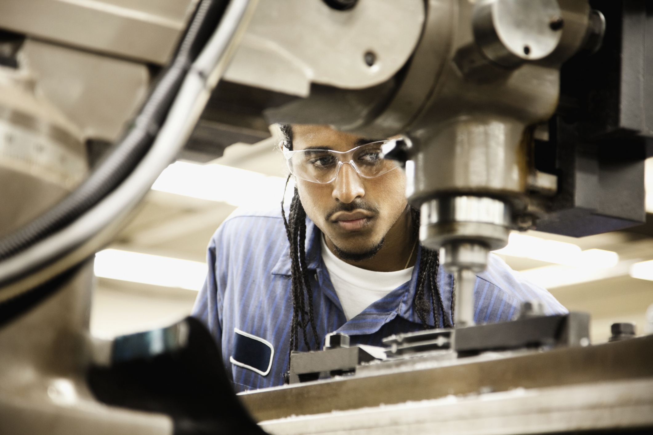 A man is wearing goggles and operating machinery