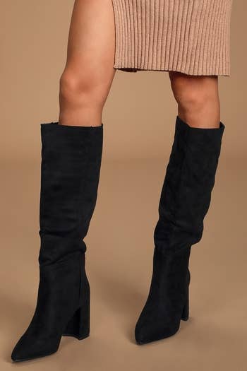 a model wearing black suede knee-high boots