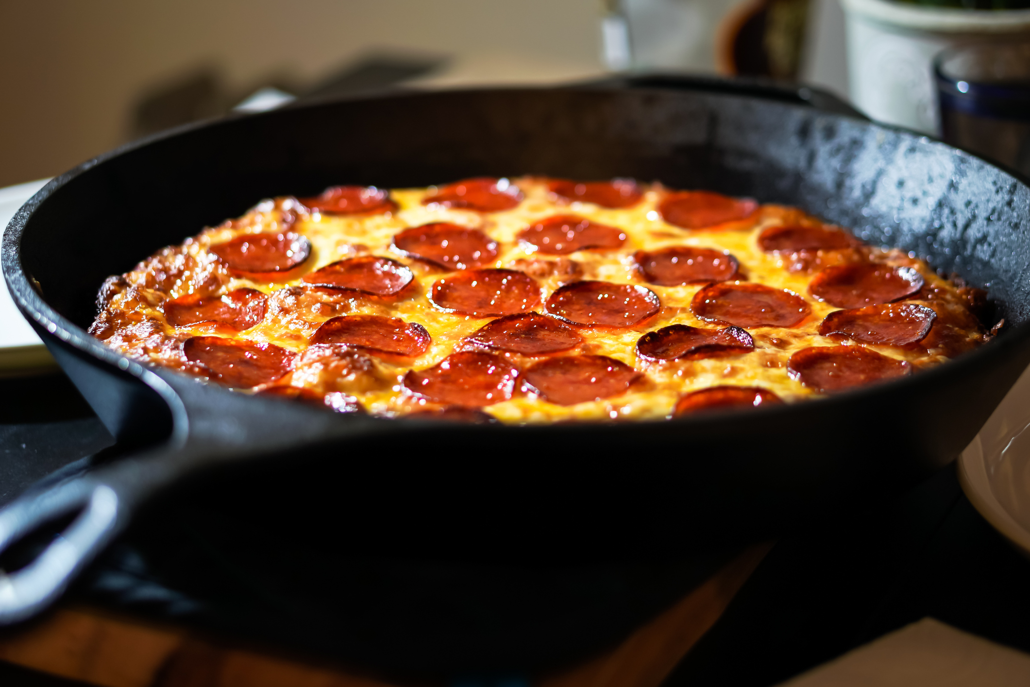 A pizza that was made in a cast-iron skillet is being shown