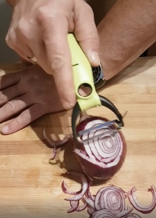 Someone cutting onions with a potato peeler