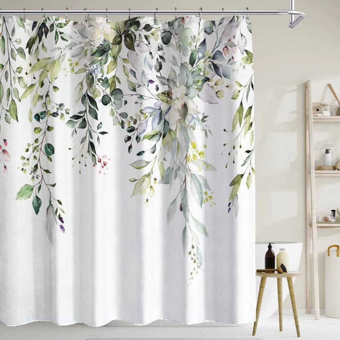 The white shower curtain with a cascading floral pattern