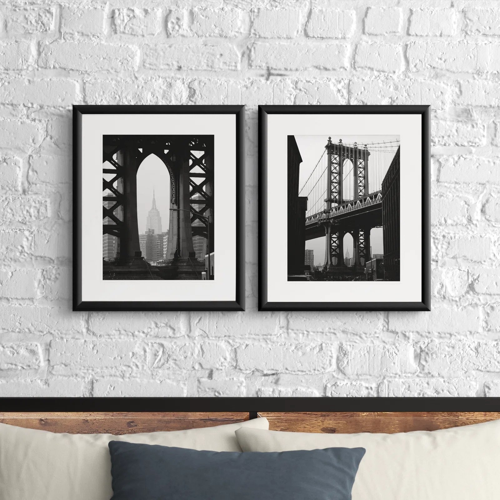 The framed prints side by side showing NYC icons: the Empire State building and the Manhattan Bridge